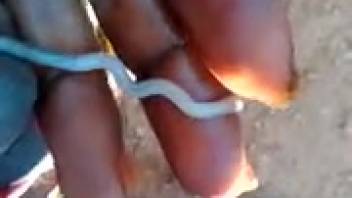 Naked man slides an extremely long worm into his penis for greater satisfaction